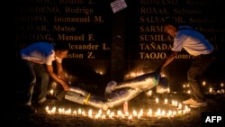 People lift a mock victim during a prayer vigil in support of the families of victims of extra-judicial killings in Manila on April 12, 2017.