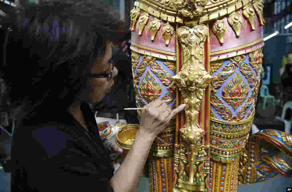 An artist paints a standing angel statue from ancient Indian epics to decorate the royal crematorium at the Fine Arts Department in Bangkok, Thailand, Aug. 8, 2017. Preparations for Thai late King Bhumibol Adulyadej's funeral are nearing completion.