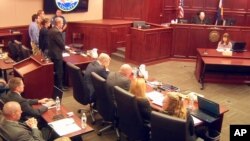 In this image taken from video, accused Colorado theater shooter James Holmes, standing on the far left, listens as the verdict is read during his trial, in Centennial, Colorado, July 16, 2015. 