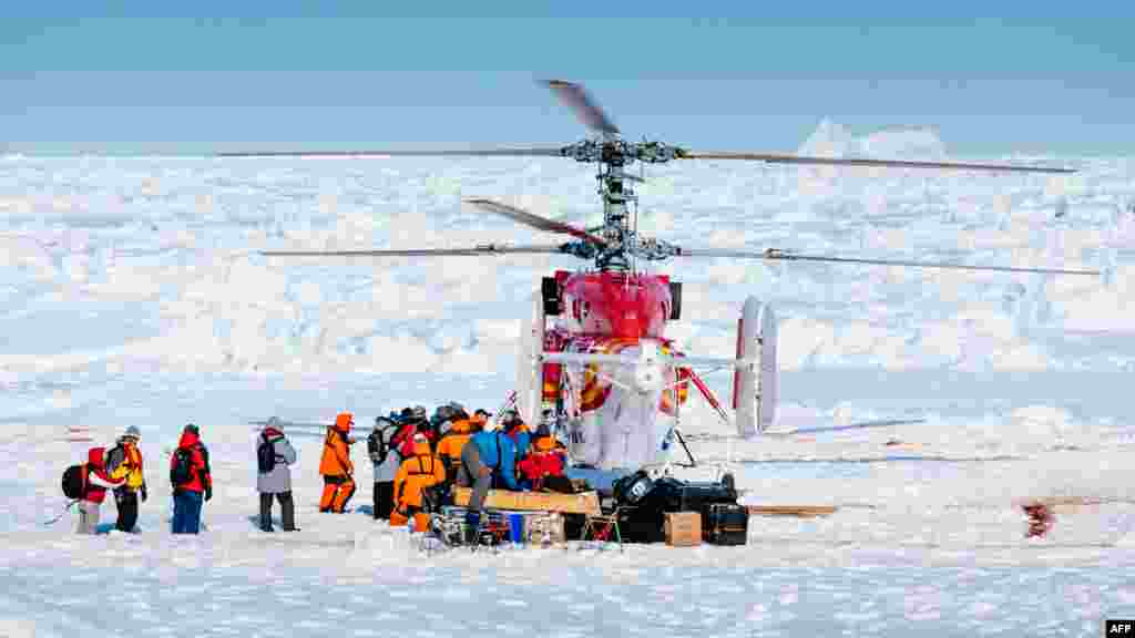 Un hélicoptère de brise-glace chinois à proximité Xue long ramassent le premier lot de passagers du navire russe Akademik MV brin Shokalskiy lors des opérations de secours qui ont lieu après plus d&#39;une semaine que les voyageurs obt été piégés dans la glace au large de l&#39;Antarctique.