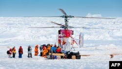 Ảnh do bác sĩ Andrew Peacock trong đoàn thám hiểm, www.footloosefotography.com, chụp một máy bay trực thăng từ chiếc tàu phá băng Tuyết Long của Trung Quốc bốc các hành khách đầu tiên từ chiếc tàu MV Akademik Shokalskiy của Nga bị kẹt ở Nam cực, 2/1/2014