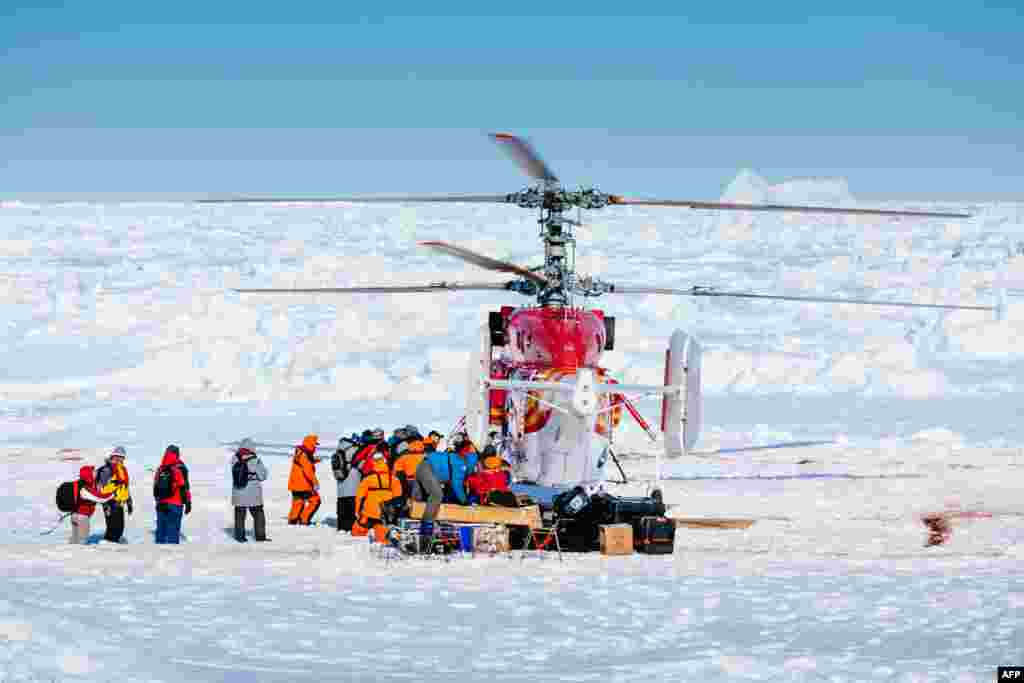 This image taken by expedition doctor Andrew Peacock of www.footloosefotography.com on Jan. 2, 2014 shows a helicopter from the nearby Chinese icebreaker Xue Long picking up the first batch of passengers from the stranded Russian ship MV Akademik Shokalskiy as rescue operations take place after over a week of being trapped in the ice off Antarctica.