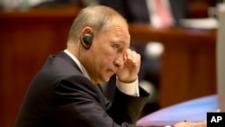 Russian President Vladimir Putin listens to a speech during the Dialogue of Emerging Market and Developing Countries in Xiamen in southeastern China's Fujian Province, Tuesday, Sept. 5, 2017. Putin dismissed as "naive" a question about whether he was disappointed in Trump.