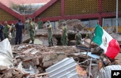 Soldiers remove debris from a partly collapsed municipal building felled by a massive earthquake in Juchitan, Oaxaca state, Mexico, Sept. 8, 2017.