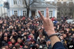 Former Georgian president Mikheil Saakashvili, back to a camera, gestures to protesters after he escaped with help from supporters and led them on a march toward parliament, where they planned to call for President Petro Poroshenko to resign in Kyiv, Dec.