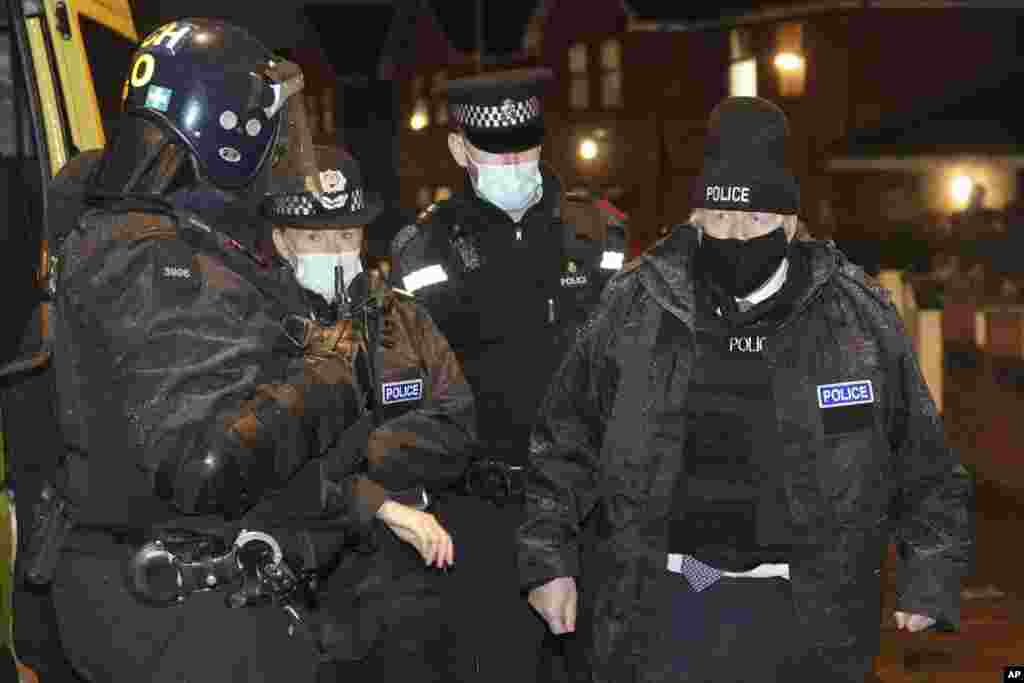 Britain&#39;s Prime Minister Boris Johnson, right, observes an early morning police raid on a home in Liverpool, England, ahead of the publication of the government&#39;s 10-year drug strategy.