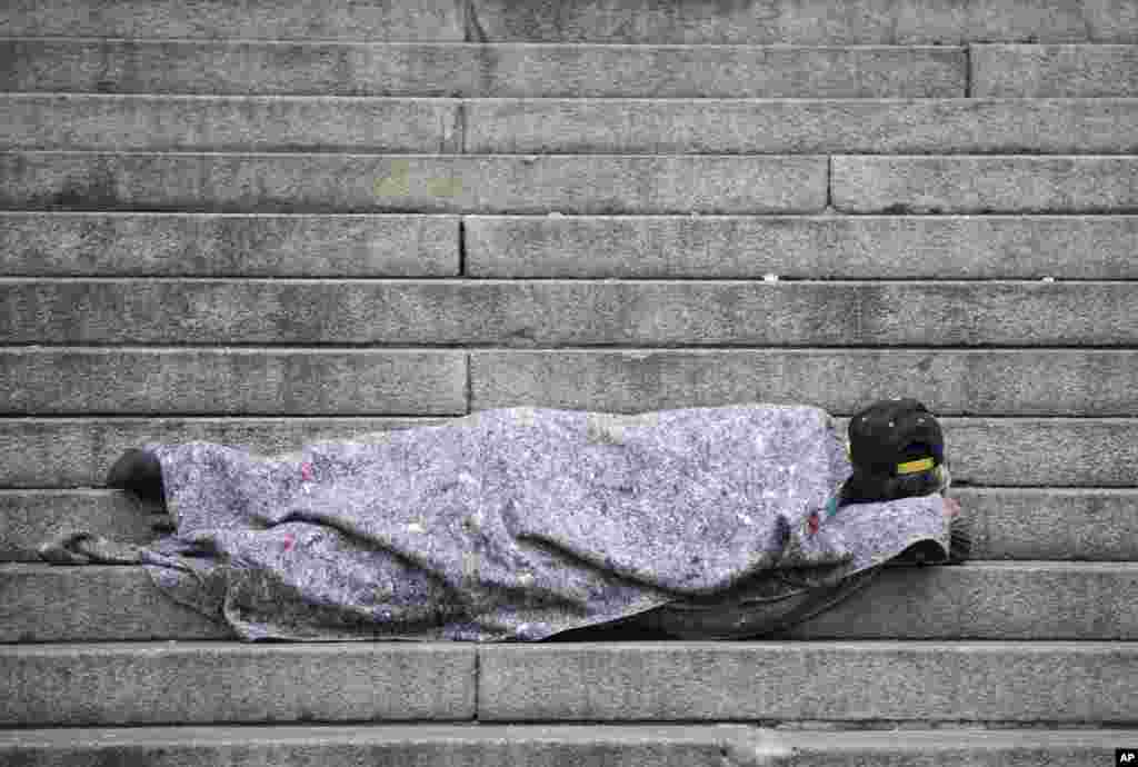 A homeless person sleeps outside the Cathedral in Sao Paulo, Brazil.