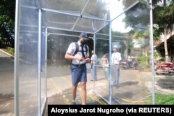 Seorang siswa yang memakai masker pelindung masuk ke dalam ruang desinfeksi di Salatiga, Provinsi Jawa Tengah, 13 Juli 2020. (Foto: Antara via Reuters)