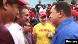 El presidente Hugo Chávez (derecha) conversa con el actor estadounidense Sean Penn durante un mitín en Valencia, unos 150 kilómetros al occidente de Caracas, el domingo 5 de agosto de 2012.