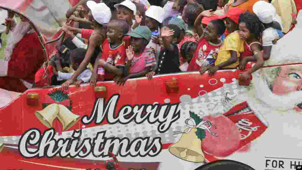 Les enfants s’offrent un tour à bord un "Santamobile (véhicule du père Noël) lors d'une fête de Noël pour les enfants défavorisés dans Maraisburg, Afrique du Sud, 7 décembre 2008.