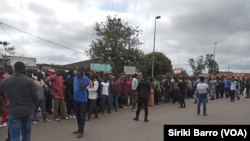 Des partisans de Jacques Mangoua encadrés par les forces de l’ordre devant le palais de justice, à Bouaké, le 30 septembre 2019. (VOA/Siriki Barro)