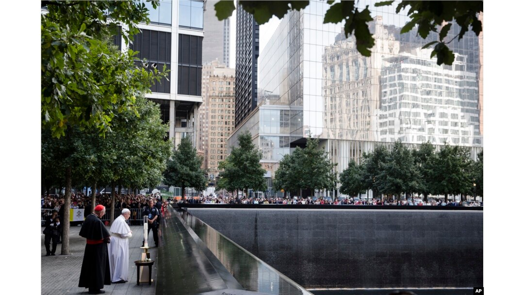 Pope Francis and Cardinal Timothy Dolan, left, pray at the South Pool of the 9/11 Memorial in New York City, Sept. 25, 2015.