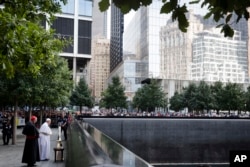 Pope Francis and Cardinal Timothy Dolan, left, pray at the South Pool of the 9/11 Memorial in New York City, Sept. 25, 2015.