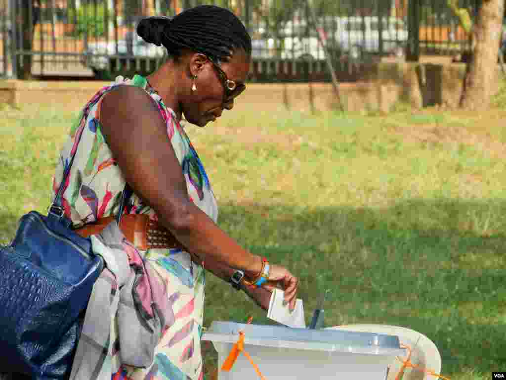 A woman votes at the National Theatre in the Central Business District of Kampala, Feb. 18, 2016. (L. Paulat/VOA)