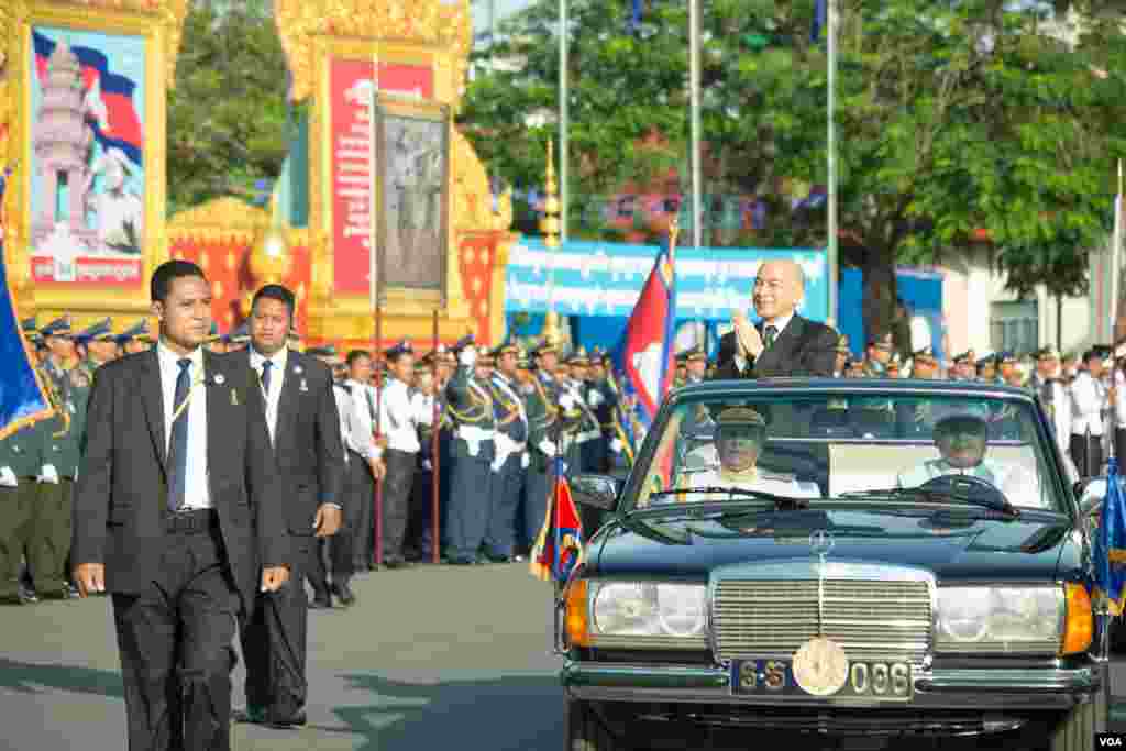 ព្រះមហាក្សត្រនៃកម្ពុជា ព្រះករុណាព្រះបរមនាថ នរោត្តម សីហមុនី ឈរក្នុងព្រះទីនាំងខណដែលព្រះអង្គយាងចេញដំណើរទៅកាន់ព្រះបរមរាជវាំងបន្ទាប់ពីបានប្រទានភ្លើងជ័យនៅក្នុងវិមានឯករាជកាលពីព្រឹកថ្ងៃទី០៩ វិច្ឆិកា២០១៨។(ទុំ ម្លិះ/VOA)