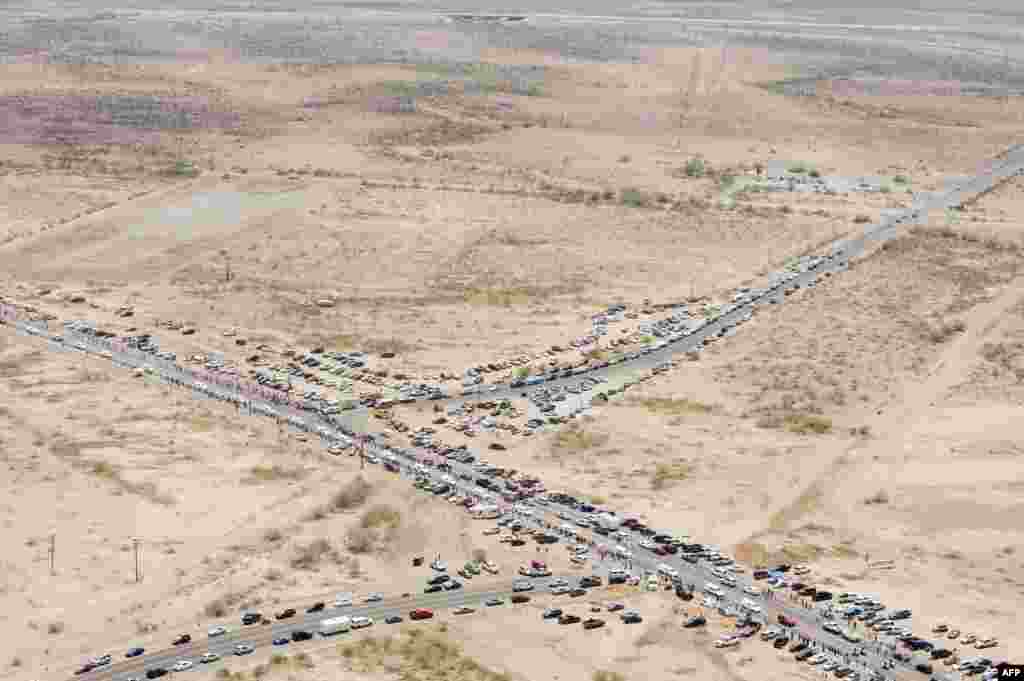 People gather along the side of the highway as the procession for the 19 fallen firefighters of the Granite Mountain Hotshots crew makes its way to Prescott in Phoenix, Arizona, USA, July 7, 2013. 19 of the 20-member crew died battling a fast-moving wildfire near Yarnell, Arizona on June 30.