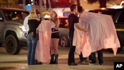 People comfort each other as they stand near the scene in Thousand Oaks, Calif., where a gunman opened fire Wednesday inside a country dance bar crowded with hundreds of people Nov. 8, 2018.