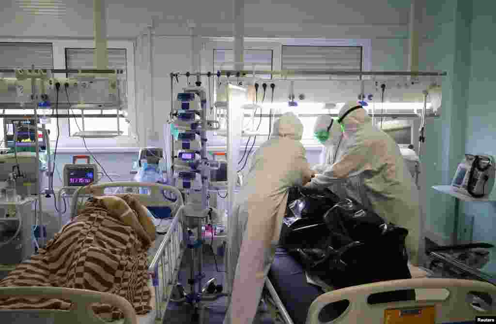 Medical specialists place the body of a person who died of COVID-19 in a bag at a local hospital in the town of Kalach-on-Don in Volgograd Region, Russia, Nov. 14, 2021.