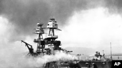 FILE - In this file image provided by the U.S. Navy, crewmen of the USS Nevada fight flames on the battleship, battered in the Japanese aerial attack on Pearl Harbor on Dec. 7, 1941. 