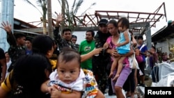 Binh sĩ giúp cư dân lên máy bay vận tải C130 của Mỹ, rời thành phố Tacloban bị bão tàn phá, ngày 11/11/2013. 