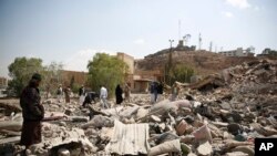 People gather as they inspect Youth and Sports Ministry's building destroyed by Saudi-led airstrikes in Sana'a, Yemen, Jan. 17, 2016. (