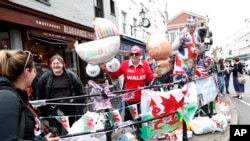 Ciudadanos se reúnen en las afueras del Castillo de Windsor en Windsor, sur de Inglaterra, el lunes 6 de mayo de 2019, después de que el Príncipe Harry anunció que su esposa Meghan, duquesa de Sussex, dio a luz a un niño para dar sus felicitaciones.