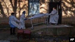 Arhiva - Medicinsko osoblje transportuje telo pacijenta koji je preminuo od posledica Kovida 19, u Rivnu, Ukrajina, 22. oktobra 2021.