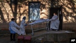 Medical staff members transport a body of a patient who died of the coronavirus at the morgue of the city hospital 1 in Rivne, Ukraine, Oct. 22, 2021. 