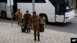 Members of the Organization for Security and Cooperation in Europe (OSCE) mission exit a bus for a hotel in Donetsk, Ukraine, March 12, 2014. 