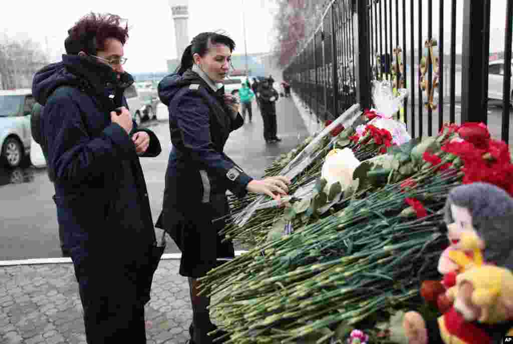 People place flowers in Kazan airport, Russia, Nov. 18, 2013.