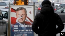 A person passes a defaced campaign poster of far-right presidential candidate Norbert Hofer in Vienna, Austria, Dec. 5, 2016. Centrist Alexander Van der Bellen defeated Hofer in Sunday's election, a win welcomed by moderate politicians across Europe.