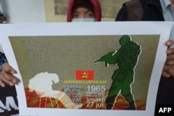 FILE - Seorang demonstran menunjukkan poster penculikan aktivis pada 1997-1998 dalam unjuk rasa memprotes pencalonan Prabowo Subianto dalam pilpres 2014, 20 Mei 2014. (Foto: AFP)