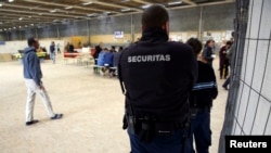 Securitas security guards stand in a Swiss federal refugee center in Thun, Switzerland, March 22, 2016.