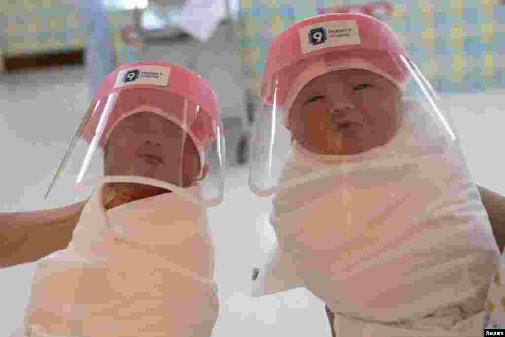 Nurses hold newborn babies wearing protective face shields at the Praram 9 hospital in Bangkok, Thailand, during the coronavirus disease (COVID-19) outbreak.