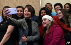 A group of Deferred Action for Childhood Arrivals program recipients take a selfie as they wait for the start of a news conference on Capitol Hill in Washington, Jan. 30, 2018, about legislation that will protect DACA recipients.