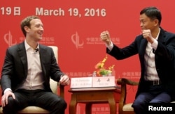 在北京的中国发展论坛会议上，脸书公司创办人和CEO扎克伯格看着马云讲话（2016年3月19日）