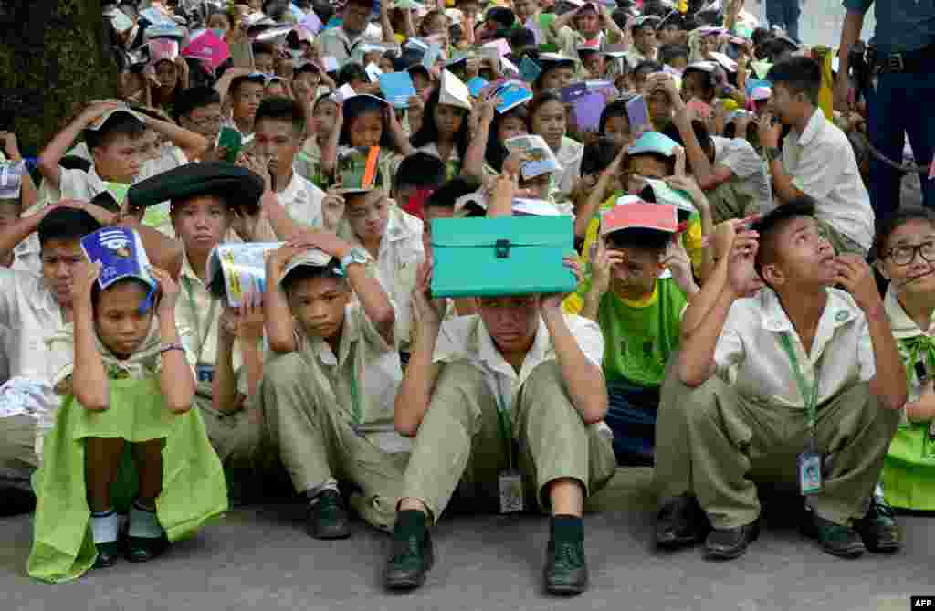 Schoolchildren take part in an earthquake and rescue drill at a government school in Manila, Philippines.