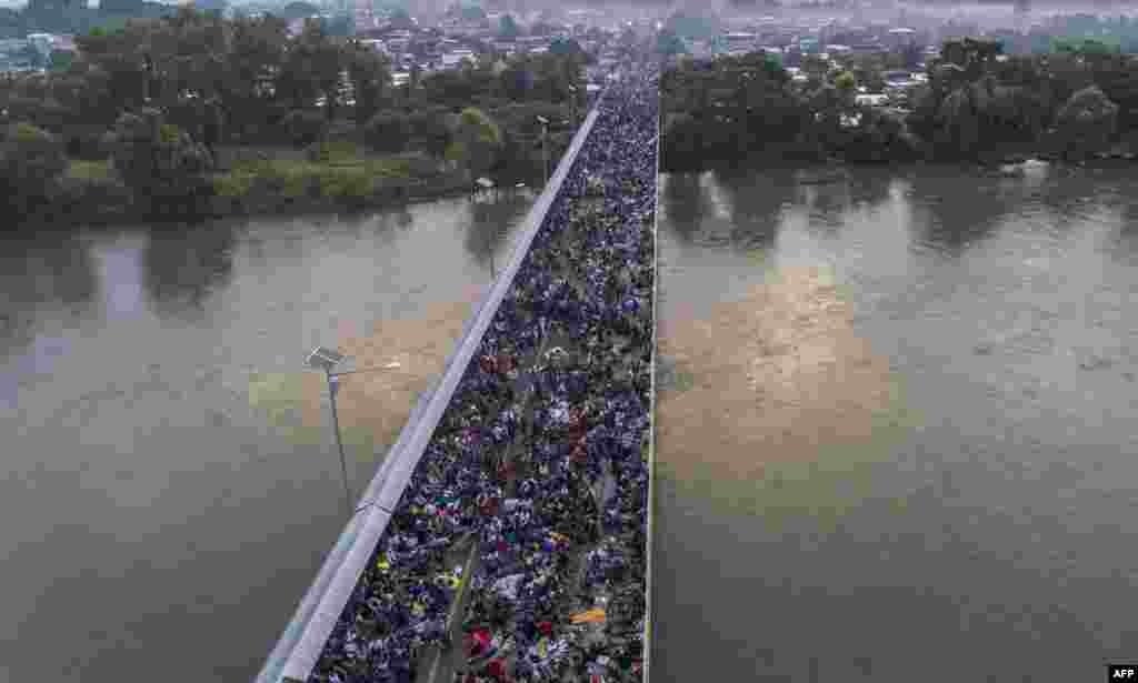 Aerial view of a Honduran migrant caravan on the Guatemala-Mexico international border bridge in Ciudad Hidalgo, Chiapas state, Mexico, Oct. 20, 2018.