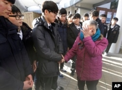 Former South Korean sex slave Park Ok-seon, right, who was forced to serve for the Japanese Army during World War II, wipes her tears as she is comforted by South Korean high school students at the House of Sharing, the home for the living sex slaves, in
