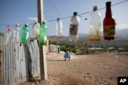 Empty bottles hang outside a beverage vendor's stall in Canaan, June 21, 2015.