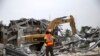 Une pelleteuse creuse dans les décombres d'un bâtiment effondré dans le quartier de Victoria Island à Lagos, le 5 novembre 2013. 