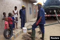 FILE - Sanitation workers removes septic waste from a house in Guediawaye, Senegal, Aug. 19, 2015. Government, charitable organizations are installing new toilets that turn waste into compost or break down matter with worms in bid to lower health risks.