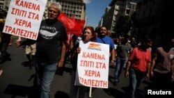 Members of the communist-affiliated PAME take part in a demonstration marking a general strike against against planned austerity measures in Athens, May 30, 2018. The placards read "No house to the hands of bankers." 