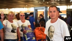 Ruski turisti u majicama sa slikom predsednika Putina čekaju na aerodromu u Šarm el-Šeiku, 6. novembra 2015.