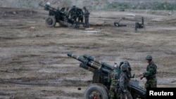 FILE - South Korean soldiers of an artillery unit check their armaments during a military drill near the demilitarized zone separating North Korea from the South, in Paju, north of Seoul.