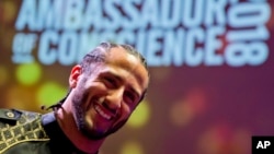 Former NFL quarterback and social justice activist Colin Kaepernick poses with guests after receiving the Amnesty International Ambassador of Conscience Award for 2018 in Amsterdam, April 21, 2018.