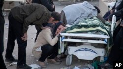 In this photo provided by Tasnim News Agency, relatives weep over the body of an earthquake victim, in Sarpol-e-Zahab, western Iran, Nov. 13, 2017. Authorities reported that a powerful 7.3 magnitude earthquake struck the Iraq-Iran border region on Monday and killed more than four hundred people in both countries. (Farzad Menati/Tasnim News Agency via AP)