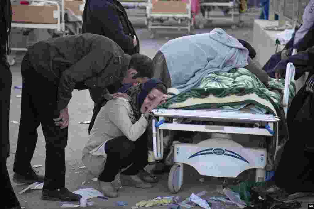 In this photo provided by Tasnim News Agency, relatives weep over the body of an earthquake victim, in Sarpol-e-Zahab, western Iran. Authorities reported that a powerful 7.3 magnitude earthquake struck the Iraq-Iran border region and killed more than 400 people in both countries, sent people fleeing their homes into the night and was felt as far west as the Mediterranean coast.