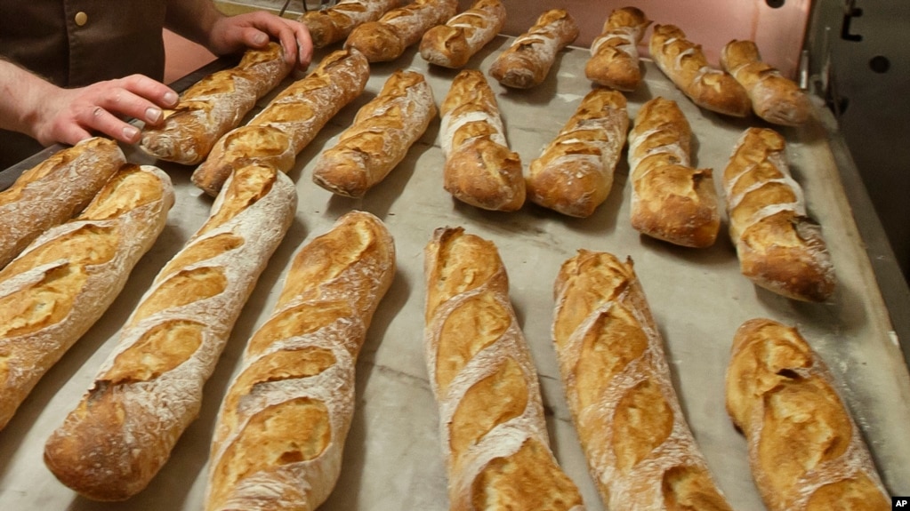 Baguettes are seen as they come out of the oven of Mickael Reydellet's bakery La Parisienne in Paris, Friday, March 18, 2016. (AP Photo/Michel Euler)