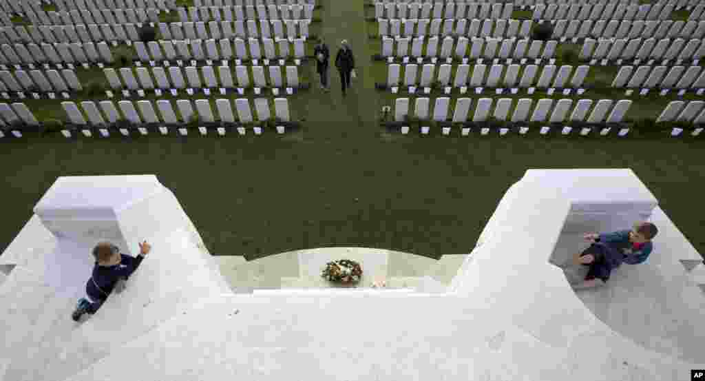 Two boys play "war" on top of a monument at the World War I Tyne Cot Commonwealth cemetery in Zonnebeke, Belgium. Tyne Cot was selected as one of several locations for an event named the "Light Front", to commemorate 100 years since the start of the First World War.